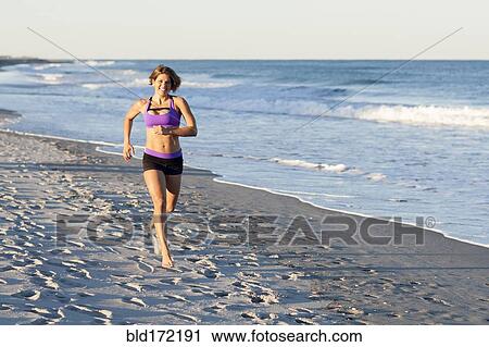 Caucasian woman jogging on beach View Large Photo Image Stock Image - Caucasian woman jogging on beach. Fotosearch
