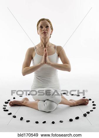 Stock Photo - Caucasian woman meditating in ring of stones. Fotosearch