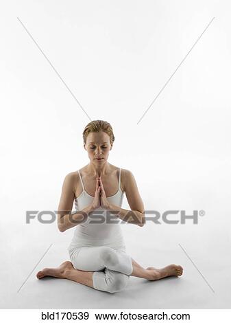 Stock Photo - Caucasian woman meditating in yoga pose. Fotosearch