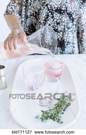 Stock Photo - Caucasian woman pouring cocktails on tray. Fotosearch