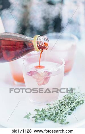 Stock Photo - Caucasian woman pouring cocktails on tray. Fotosearch
