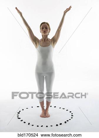 Picture - Caucasian woman practicing yoga in ring of stones. Fotosearch