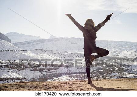 Stock Image - Caucasian woman practicing yoga on remote hilltop. Fotosearch