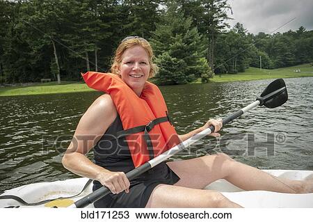 Caucasian woman rowing canoe in lake View Large Photo Image Stock Image - Caucasian woman rowing canoe in lake. Fotosearch