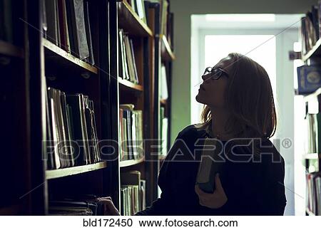 Caucasian woman searching for book in library View Large Photo Image Stock Image - Caucasian woman searching for book in library. Fotosearch