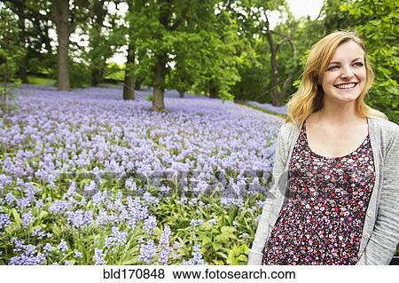 Stock Photo - Caucasian woman smiling in field of flowers. Fotosearch