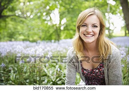 Stock Photography - Caucasian woman smiling in field of flowers. Fotosearch