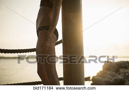 Caucasian woman standing by lake at sunset View Large Photo Image Picture - Caucasian woman standing by lake at sunset. Fotosearch