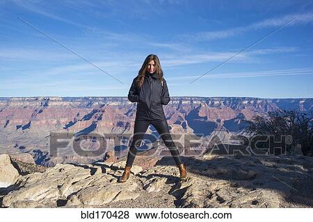 Stock Photo - Caucasian woman standing over Grand Canyon, Arizona, United States. Fotosearch