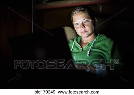 Caucasian woman using laptop at night View Large Photo Image Stock Photo - Caucasian woman using laptop at night. Fotosearch