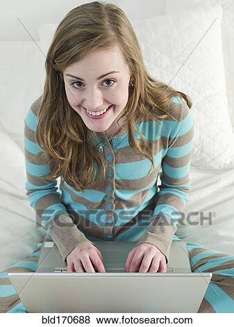 Caucasian woman using laptop on bed View Large Photo Image Stock Photo - Caucasian woman using laptop on bed. Fotosearch