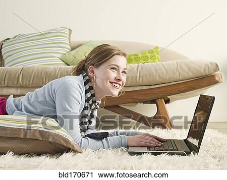 Caucasian woman using laptop on carpet View Large Photo Image Stock Image - Caucasian woman using laptop on carpet. Fotosearch