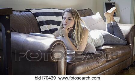 Caucasian woman using laptop on sofa View Large Photo Image Stock Photo - Caucasian woman using laptop on sofa. Fotosearch