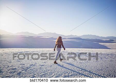 Stock Image - Caucasian woman walking in White Sands National Park, New Mexico, United States. Fotosearch