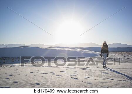 Stock Photo - Caucasian woman walking in White Sands National Park, New Mexico, United States. Fotosearch