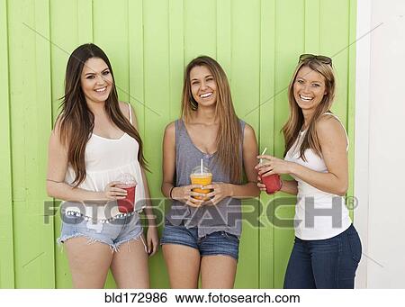 Stock Photograph - Caucasian women drinking juice. Fotosearch