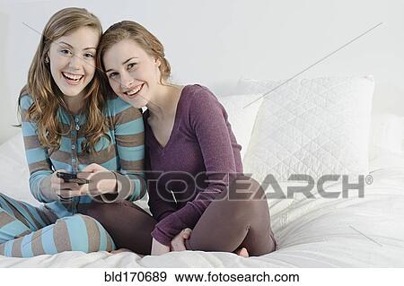 Stock Photo - Caucasian women hugging on bed. Fotosearch
