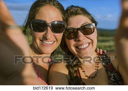Caucasian women in sunglasses taking selfie View Large Photo Image Stock Photo - Caucasian women in sunglasses taking selfie. Fotosearch
