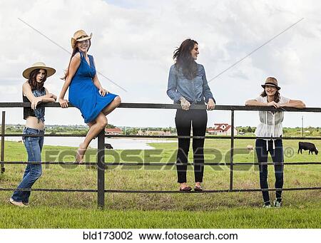 Caucasian women standing on ranch gate View Large Photo Image Stock Image - Caucasian women standing on ranch gate. Fotosearch