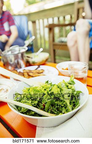 Stock Image - Close up of bowl of salad on lunch table. Fotosearch