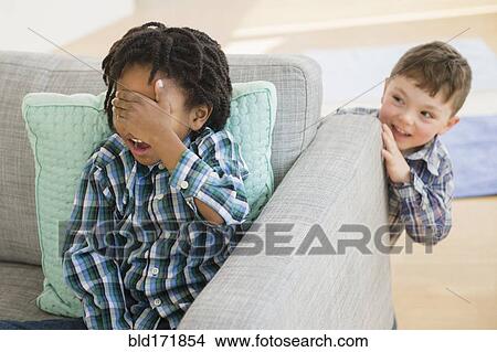 Close up of boys playing hide and seek in living room View Large Photo Image Picture - Close up of boys playing hide and seek in living room. Fotosearch