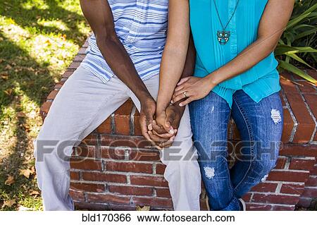 Close up of couple holding hands in garden View Large Photo Image Stock Photograph - Close up of couple holding hands in garden. Fotosearch