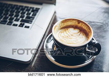 Stock Image - Close up of cup of coffee with latte art. Fotosearch
