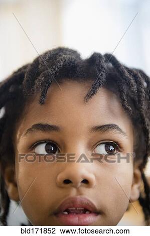 Stock Image - Close up of curious mixed race boy. Fotosearch