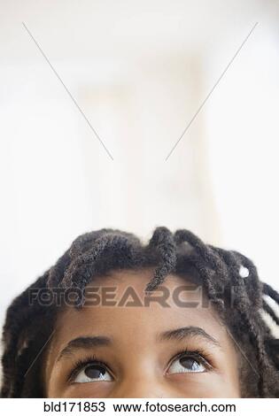 Stock Image - Close up of mixed race boy looking up. Fotosearch
