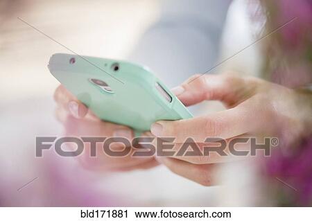 Stock Image - Close up of mixed race woman using cell phone. Fotosearch