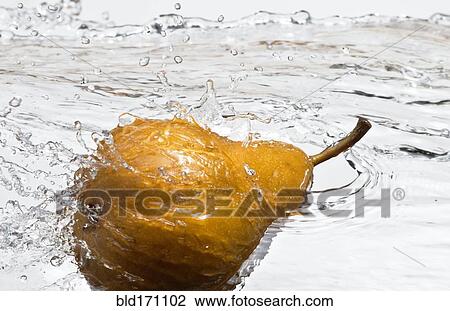 Stock Image - Close up of pear splashing in water. Fotosearch