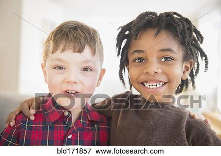 Stock Photo - Close up of smiling boys hugging. Fotosearch