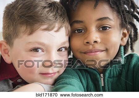 Stock Image - Close up of smiling boys taking selfie. Fotosearch