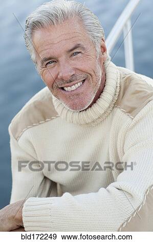 Stock Photo - Close up of smiling Caucasian man on boat deck. Fotosearch