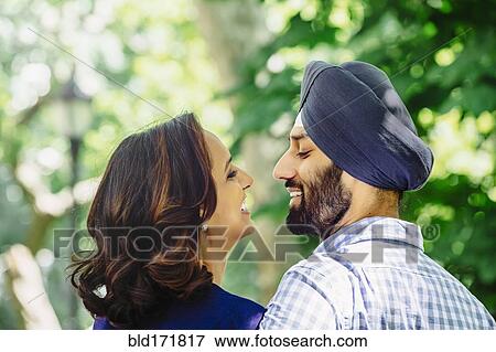 Stock Photo - Close up of smiling Indian couple hugging. Fotosearch