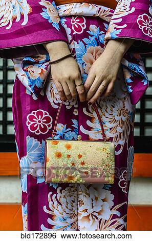 Stock Photograph - Close up of woman in kimono holding purse. Fotosearch