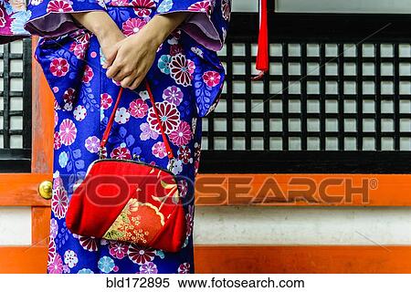 Stock Photography - Close up of woman in kimono holding purse. Fotosearch