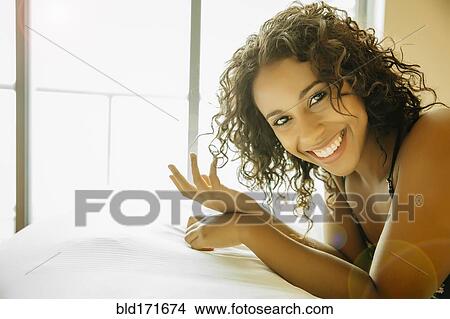Picture - Close up of woman laying on hotel bed. Fotosearch