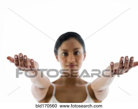 Stock Image - Close up of woman meditating with arms outstretched. Fotosearch