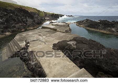 Stock Image - Concrete path to public swimming pool near ocean. Fotosearch