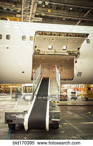 Conveyor belt leading to airplane cargo hold View Large Photo Image Stock Photography - Conveyor belt leading to airplane cargo hold. Fotosearch