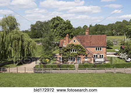 Stock Image - Country house and rural fields. Fotosearch