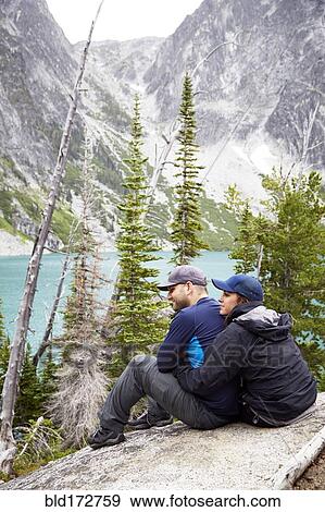 Stock Photo - Couple admiring mountains and remote lake. Fotosearch