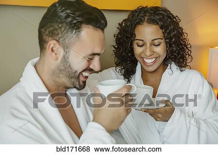 Stock Photo - Couple drinking coffee in hotel room. Fotosearch