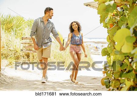 Couple holding hands and walking on beach View Large Photo Image Stock Image - Couple holding hands and walking on beach. Fotosearch