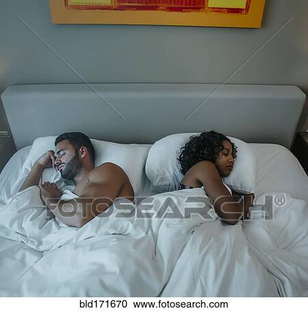 Stock Image - Couple sleeping in bed. Fotosearch