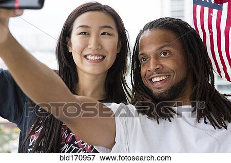 Couple taking selfie with American flag View Large Photo Image Stock Photo - Couple taking selfie with American flag. Fotosearch