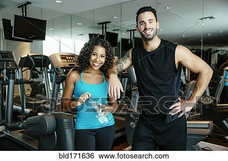 Stock Photograph - Couple working out together in gymnasium. Fotosearch