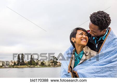 Couple wrapped in blanket outdoors View Large Photo Image Stock Photo - Couple wrapped in blanket outdoors. Fotosearch