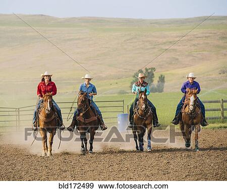 Cowgirls and cowboy riding horses on ranch View Large Photo Image Stock Photo - Cowgirls and cowboy riding horses on ranch. Fotosearch
